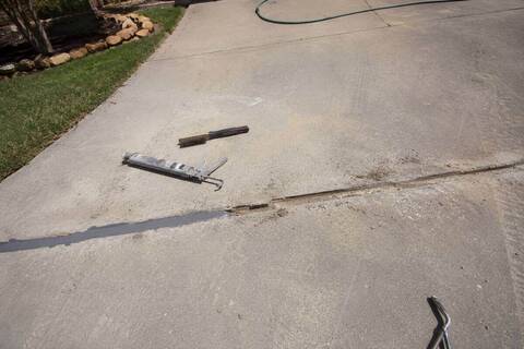 Routed channel in a driveway partly filled with sealant