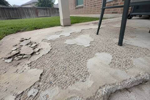 Spalled patio surface with the top layer flaked away