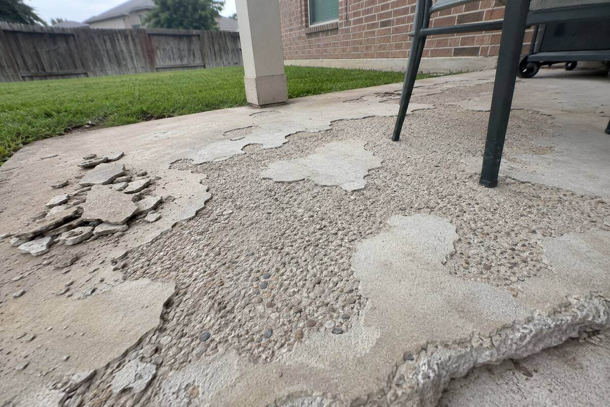 Spalled patio surface with the top layer flaked away